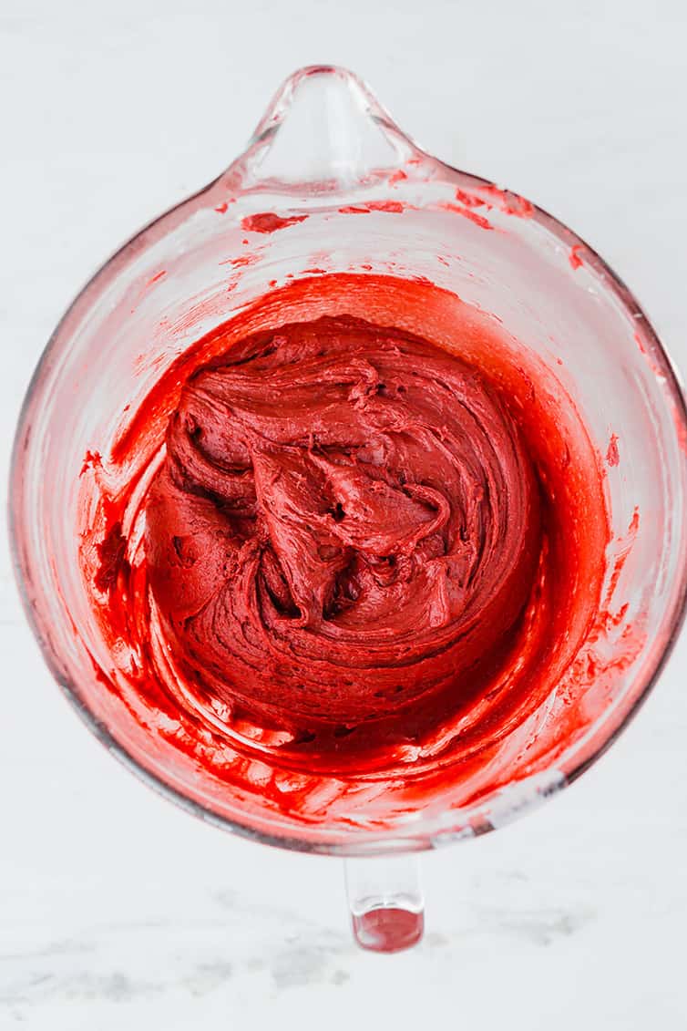 A glass mixing bowl with red velvet cookie batter.