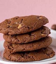 Stack of 4 chocolate malted whopper cookies on a white plate.