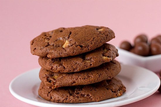 Stack of 4 chocolate malted whopper cookies on a white plate.