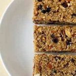Overhead image of 3 homemade granola bars on a white plate.