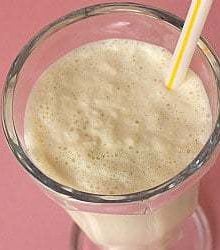 Malted vanilla milkshake in a glass with a straw.