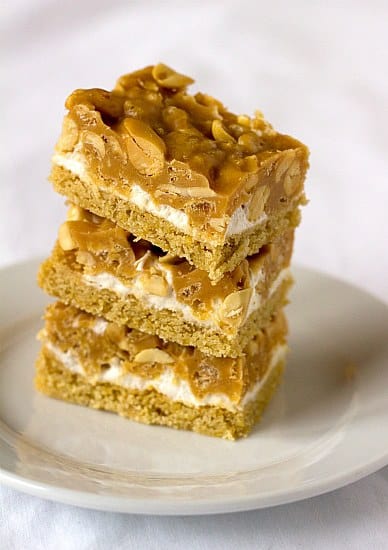 Stack of 3 salted peanut chew bars on a white plate.