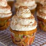 Frosted tiramisu cupcakes on a cooling rack.