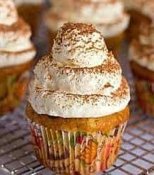 Frosted tiramisu cupcakes on a cooling rack.