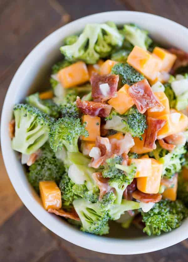 A bowl of broccoli salad with cheese and bacon.