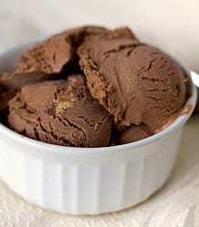 Scoops of chocolate peanut butter cup ice cream in a white bowl.