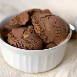 Scoops of chocolate peanut butter cup ice cream in a white bowl.