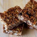 3 granola bars on a wood surface.