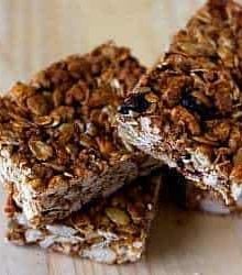 3 granola bars on a wood surface.