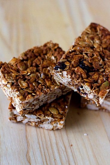Stack of homemade granola bars on a wood surface.