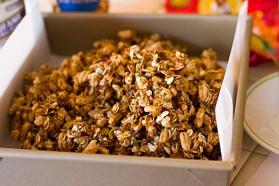 Homemade granola bar mixture in a parchment paper lined baking pan.