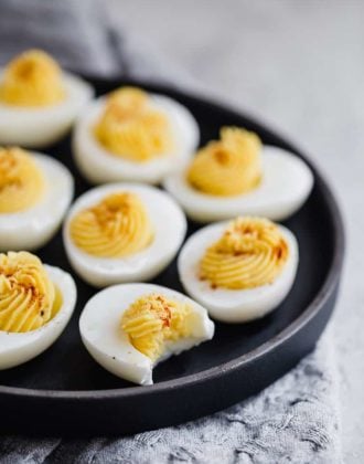 A black tray with filled deviled eggs.