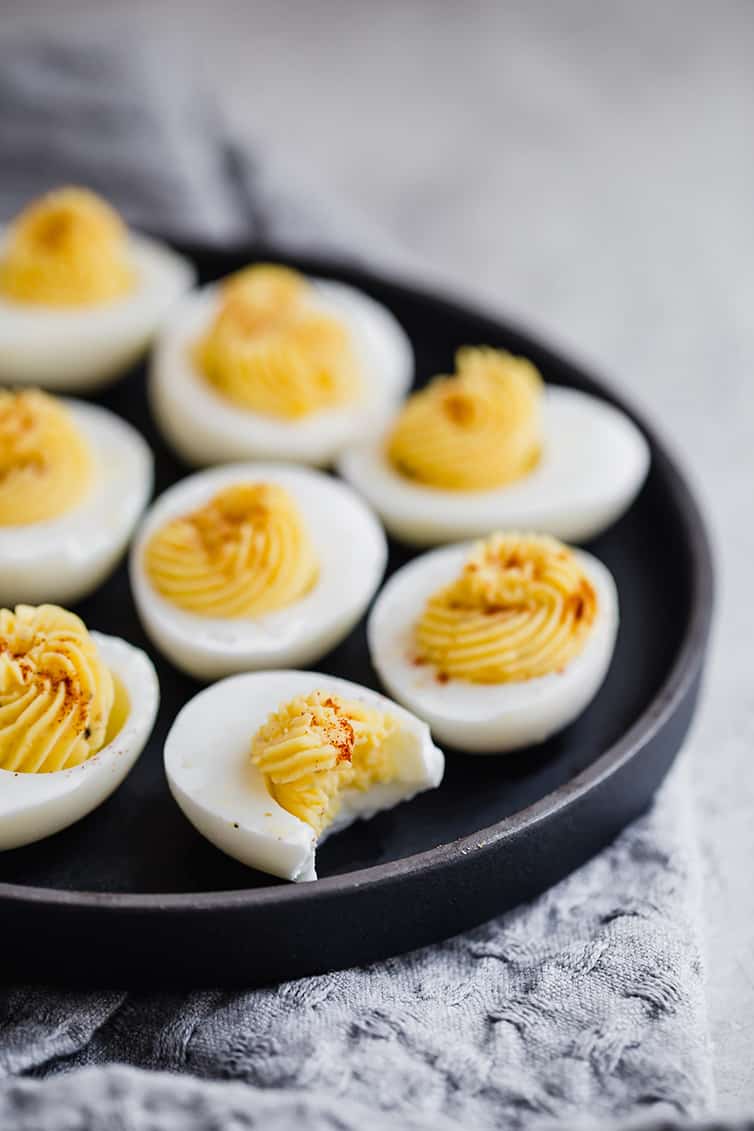 A black tray with filled deviled eggs.