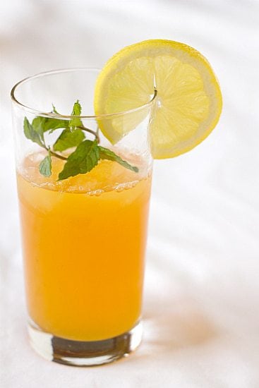 Ginger tea lemonade in a glass garnished with a lemon round.