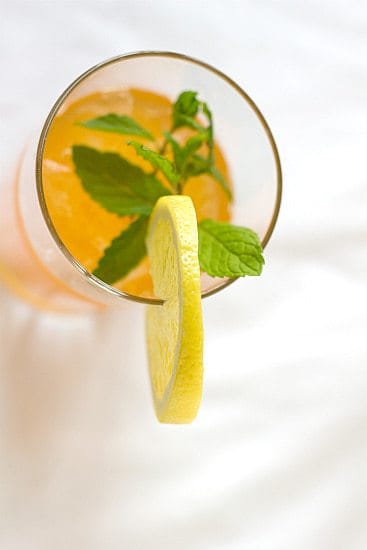 Overhead image of ginger tea lemonade in a glass garnished with a lemon round.