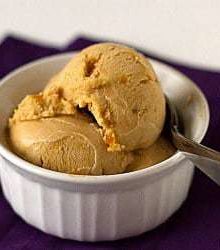Scoops of salted caramel ice cream in a white bowl with a spoon.