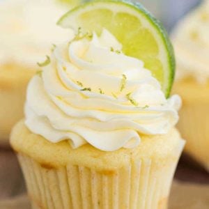 Vanilla cupcake topped with vanilla frosting, sprinkled with lime zest and topped with lime wedge.
