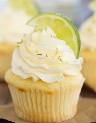 Vanilla cupcake topped with vanilla frosting, sprinkled with lime zest and topped with lime wedge.