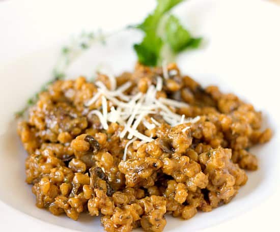 A serving of mushroom barley risotto on a white plate.