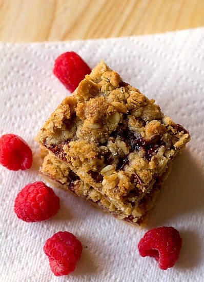Overhead image of a stack of raspberry streusel bars on a paper towel.