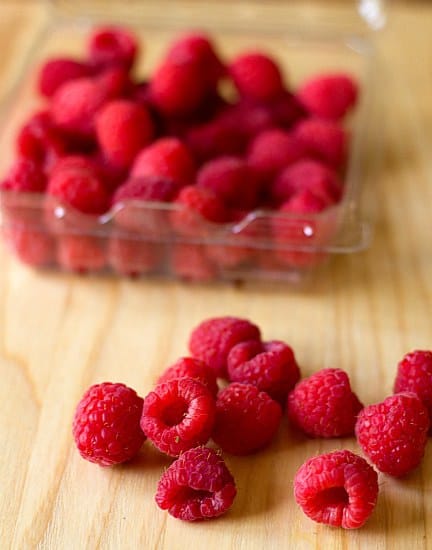 Fresh raspberries on a wood surface.