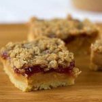 Peanut butter and jelly pie bars on a wood board.