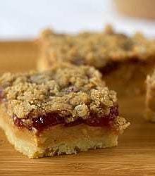 Peanut butter and jelly pie bars on a wood board.