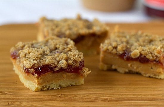 Peanut butter and jelly bars on a wood board.