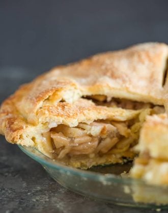 A fresh baked apple pie sliced into so you can see the filling.