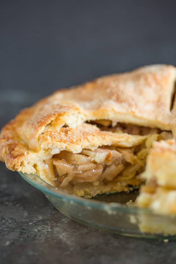 A fresh baked apple pie sliced into so you can see the filling.