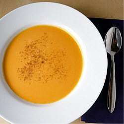 Overhead image of butternut squash soup in a white bowl.