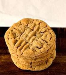 Stack of peanut butter cookies on a wood board.