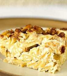 Square of noodle kugel on a cream colored plate.