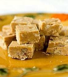 Squares of pumpkin fudge on a gold colored plate.