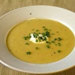 Creamy potato and leek soup in a white bowl.
