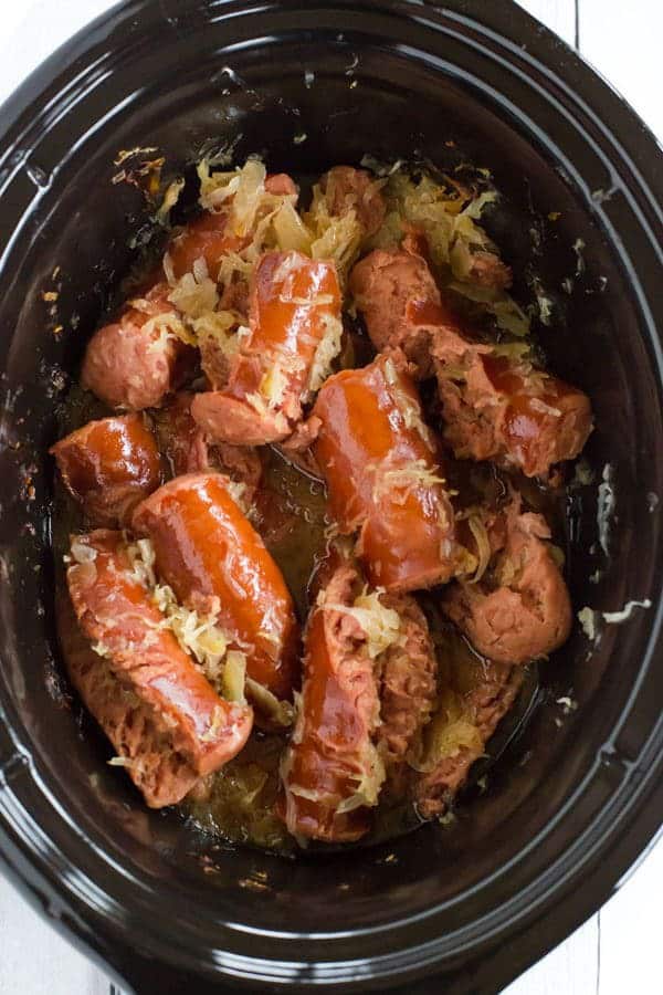 This slow cooker kielbasa and sauerkraut is flavorful and made with just the addition of beer and brown sugar - easy, delicious and perfect for parties!