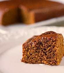 Slice of gingerbread cake on a white plate.