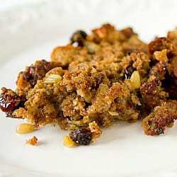 Serving of sausage, fig, and cranberry stuffing on a white plate.