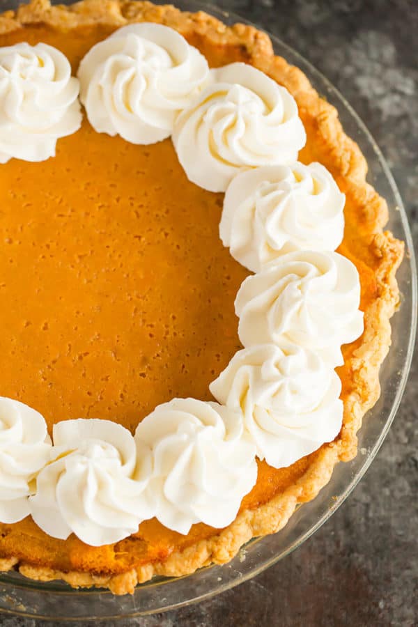 An overhead shot of a sweet potato pie with whipped cream around the borders.