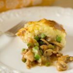 Serving of turkey pot pie on a white plate with a fork.