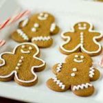 Decorated gingerbread men cookies on a white plate.