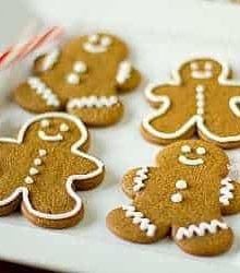 Decorated gingerbread men cookies on a white plate.
