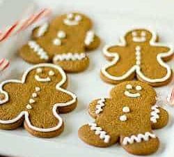 Decorated gingerbread men cookies on a white plate.