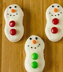 Nutter Butter cookies dipped in white chocolate and decorated like snowmen with M&Ms and frosting.