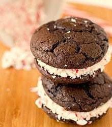 Stack of 2 chocolate peppermint whoopie pies on a wood board.
