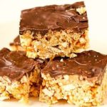 A stack of chubby hubby Rice Krispie treats topped with a layer of chocolate.