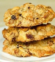 Stack of 3 granola cookies on a white plate.