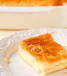 Square of Greek custard pie on a white plate.