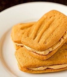 3 peanut butter sandwich cookies on a white plate.