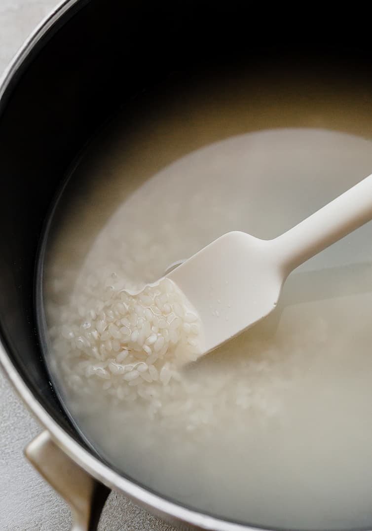 Rice being cooked in a pot on the stove.